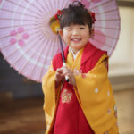 着物姿で和傘を持った3歳女の子