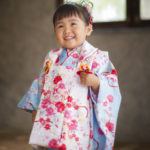 アンティークの窓辺で笑顔を見せる被布を着た３歳女の子
